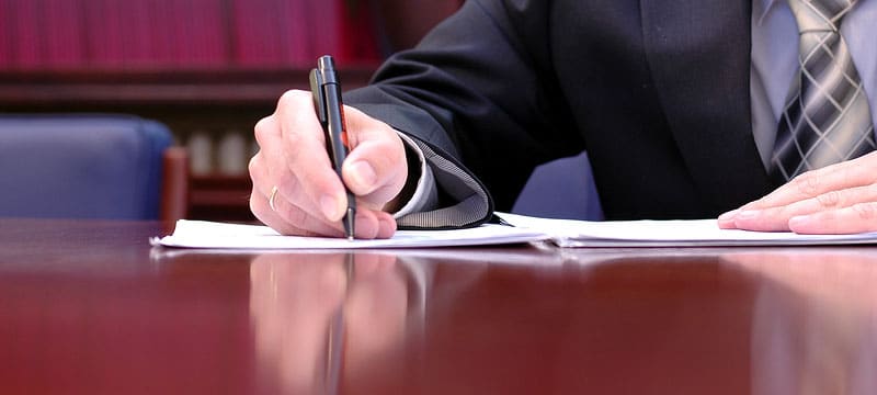 Man writing at desk during Court Reporting Process